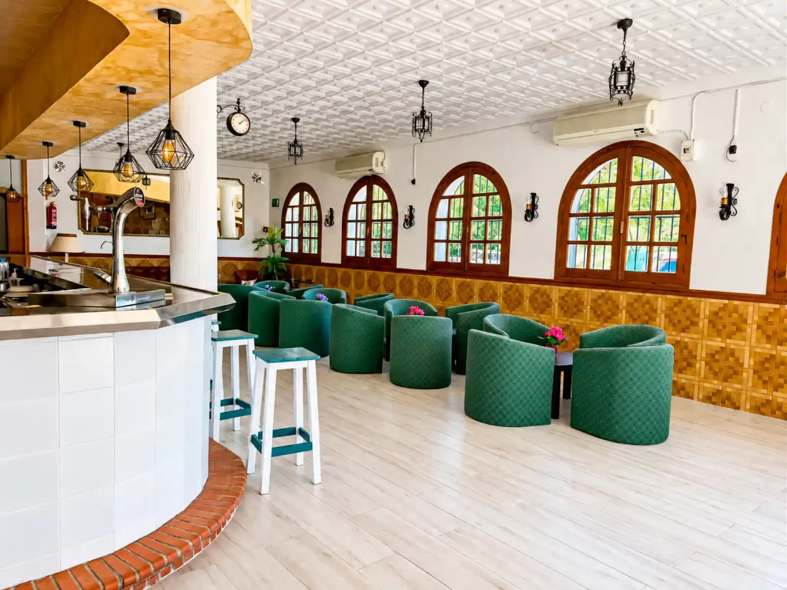 Salón con sillones verdes y bar
